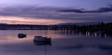 The luxurious view of city lights as they streak across the water at sunset on Lake Taupo. Photo / Alan Gibson