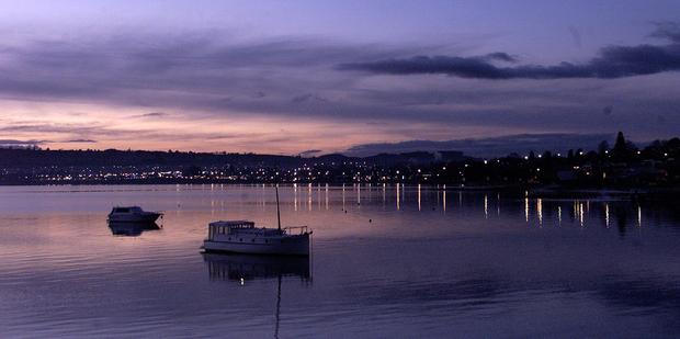 The luxurious view of city lights as they streak across the water at sunset on Lake Taupo. Photo / Alan Gibson