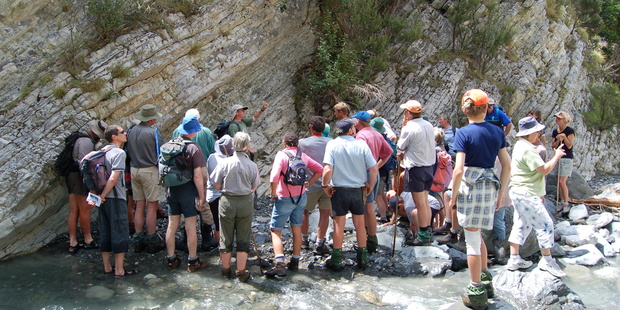 Dr Chris Hollis shows local farmers the work they are doing in Mead Stream, Clarence River Valley and points out a rock outcrop that records a global warming event 55 million years ago. Photo / Supplied