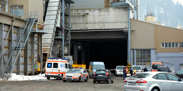 Police stand in front of a wood-processing company in Menznau, central Switzerland, where two people were killed in a shooting. Photo / AP