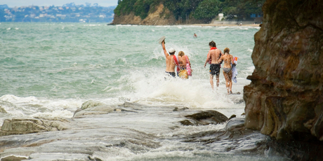 Youngsters take the wet way home along the walkway between Murrays Bay and Mairangi Bay. Photo / Paul Estcourt