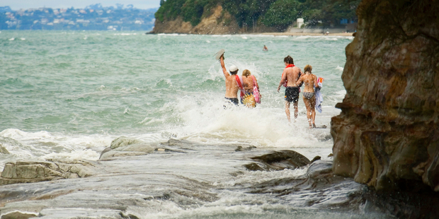 Youngsters take the wet way home along the walkway between Murrays Bay and Mairangi Bay. Photo / Paul Estcourt
