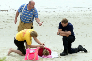 A lifeguard helps a rescued swimmer. Photo / Otago Daily Times