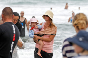 Meg Strange and her daughter Indigo join others at the re-opening of Muriwai Beach to reclaim their special place yesterday. Photo / Michael Craig