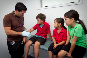 Dr O'Sullivan checks Brennan Morgan's arm at Te Kura Kaupapa Maori o Pukemiro school. Photo / Natalie Slade