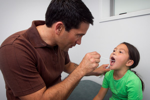 Dr Lance O'Sullivan swabs 7-year-old Raukura McNab's throat. Photo / Natalie Slade