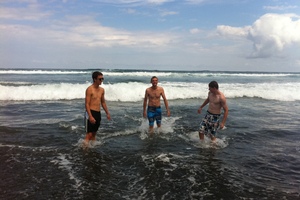 Friends Joseph Wilson (left), Charlie Cartwright and Aaron Fell had a swim at Bethells Beach despite the attack. Photo / APNZ