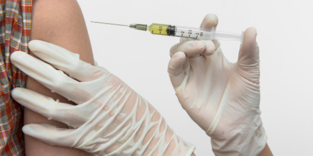 doctor puts a syringe in arm of children