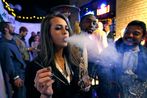 Partygoers smoke marijuana during a Prohibition-era themed New Year's Eve party celebrating the start of retail pot sales. Photo / AP