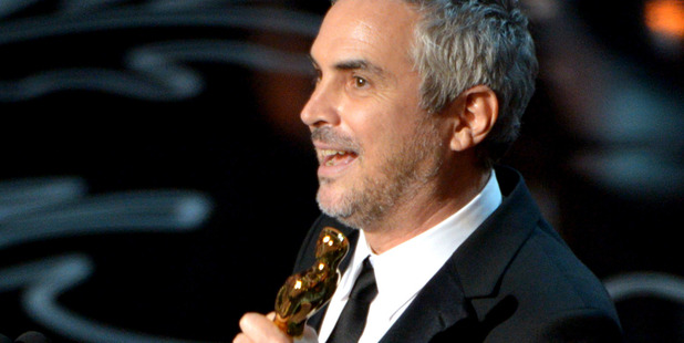 Alfonso Cuaron accepts the award for best director for Gravity during the Oscars. Photo/AP