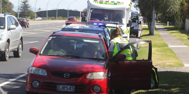 A woman gets attended to by St Johns staff after a crash on Maunganui Rd.
Photo: John Borren