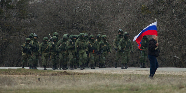 Vladimir Putin's army flexes its muscles at a Ukraine military facility in Crimea with Russian soldiers surrounding the base, blocking its soldiers from leaving. Photo / AP