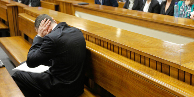 Oscar Pistorius blocks his ears inside the High Court on the second day of his trial in Pretoria. Photo / AP