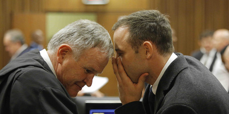 Oscar Pistorius, talks with his attorney, Barry Roux, left, inside court on the second day of his trial. Photo / AP