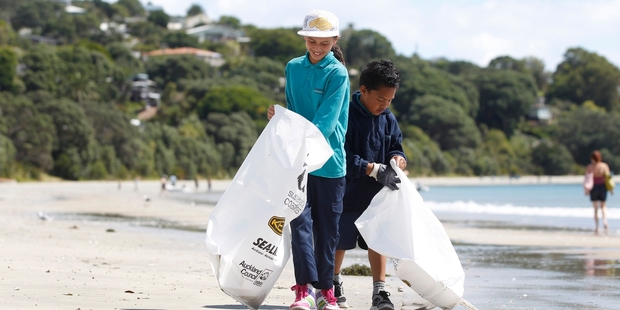 Mercy Kiddie, left, and Sam Tuimauga, from Dawson Primary, fill up their bags with beach litter. Photo / Chris Gorman
