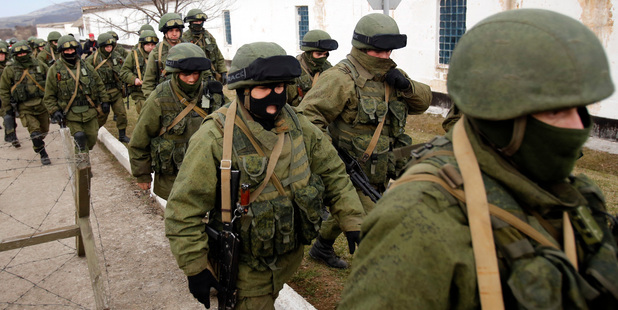 Unidentified armed men patrol around a Ukraine's infantry base in Perevalne, Ukraine. Photo / AP
