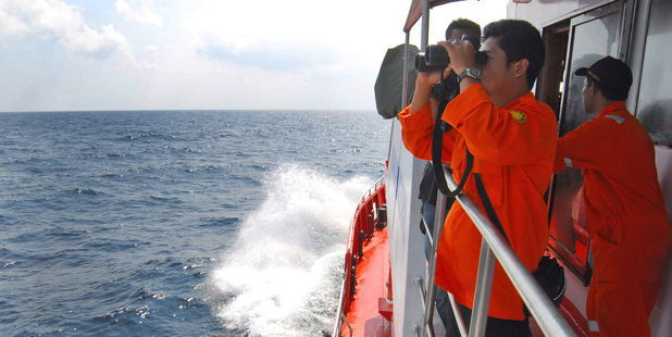 A member of the Indonesian National Search and Rescue Agency (BASARNAS) uses a binocular to scan the horizon during a search operation for the missing Malaysia Airlines flight. Photo / AP