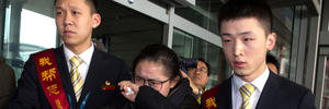 A woman in tears is helped by airport workers to a bus waiting for relatives of the missing Malaysian airliner at the international airport in Beijing, China. Photo / AP