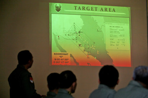 Indonesian Air Force officers examine the projection of a map that shows their operation area over the Strait of Malacca. Photo / AP