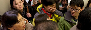 Anxious relatives and media at the Beijing airport. Photo / AP