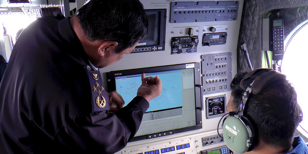 Malaysian Maritime Enforcement Agency chief Admiral Mohd Amdan Kurish discusses the search with a radar operator. Photo / AP