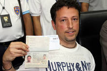 Italian Luigi Maraldi, whose stolen passport was used by a passenger boarding a missing Malaysian airliner, shows his passport as he reports himself to Thai police at Phuket police station. Photo / AP
