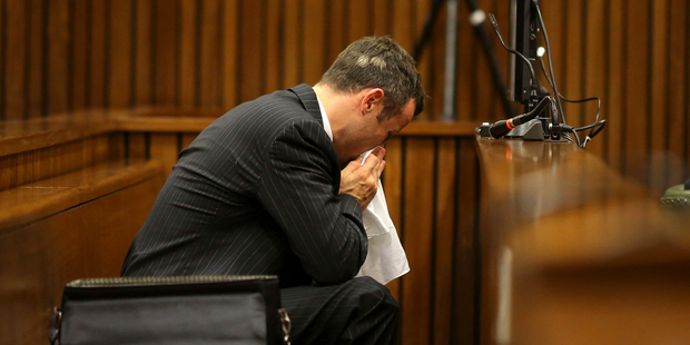 Oscar Pistorius blows his nose after reaching for a bucket as he listened to cross questioning about the events surrounding the shooting death of his girlfriend. Photo / AP