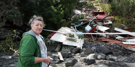 Shirley Harris with her demolished bach caused by Cyclone Wilma in Onetangi on Waiheke Island. Photo / Herald on Sunday