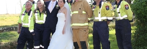 THANK YOU: Volunteer fire crew, mainly from Featherston fire station, surround Wellington newlyweds Tom Knobloch and Micaela Yee at the Brackenridge Country Retreat and Spa near Martinborough. The crew, plus others from Martinborough and Carterton, were called out to battle a tree and scrub fire on the estate's southern boundary.PHOTOS/ANDREW BONALLACK WTA080314ABFIRE02