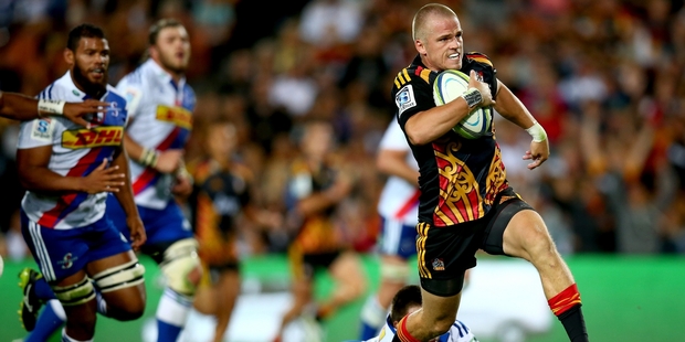 Gareth Anscombe beats the tackle of Jozua Francois Malherbe and carries the Chiefs forward during their 36-20 victory over South Africa's Stormers in Hamilton last night. Photo / Getty Images