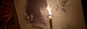 A Malaysian ethnic Chinese woman holds a placard as she takes part in a vigil for missing Malaysia Airlines passengers in KL. Photo / AFP