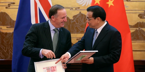 Prime Minister John Key and Premier Li Keqiang exchange banknotes in Beijing. Photo / AP