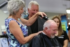 Whangarei Mayor Sheryl Mai deals to her husband's hair. Photo / APN Whangarei Mayor Sheryl Mai deals to her husband's hair. Photo / APN
