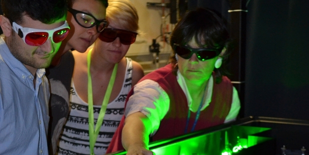 Cather Simpson (right) instructs students on how to use the femtosecond laser at the Photon Factory.