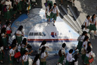 Students from the Benigno 'Ninoy' Aquino High School walk on a mural depicting the missing Malaysia Airlines plane. Photo / AP