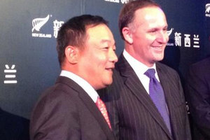 John Key and Stone Shi, Oravida's chairman, pose for photos in Beijing last night. Photo / Laura McQuillan, Newstalk ZB