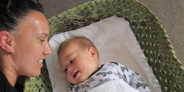 Shayle Pilcher and her son Floyd in a wahakura (woven bassinet) made by his dad Paul.