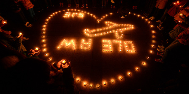 University students hold a candlelight vigil for passengers on the missing Malaysia Airlines Flight MH370. Photo / AP