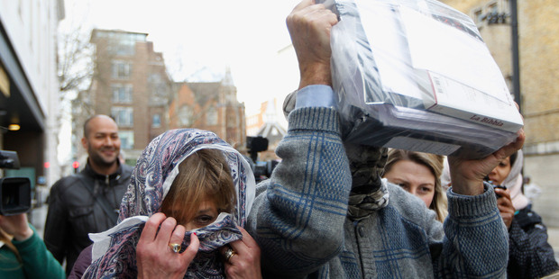 Convicted mafia boss Domenico Rancadore, right, and his wife Anne Skinner, with their faces covered leaving Westminster Magistrates Court. Photo / AP