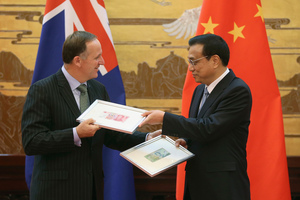 New Zealand Prime Minister John Key, left, and Chinese Premier Li Keqiang exchange Chinese Yuan and New Zealand Dollar banknotes. Photo / AP