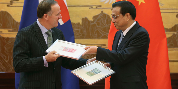 New Zealand Prime Minister John Key, left, and Chinese Premier Li Keqiang exchange Chinese Yuan and New Zealand Dollar banknotes. Photo / AP