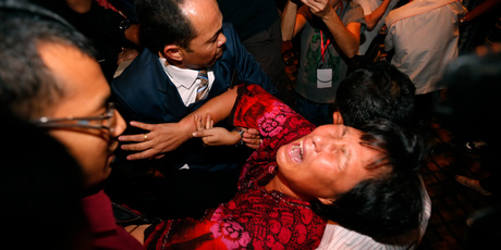 A Chinese relative of a passenger aboard a missing Malaysia Airlines plane is carried out by security officials as she protests before a press conference. Photo / AP