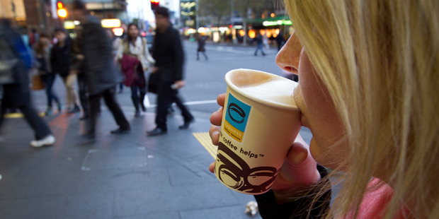 A woman drinks a regular flat white coffee from Esquires on Queen Street, Auckland. Photo / Sarah Ivey