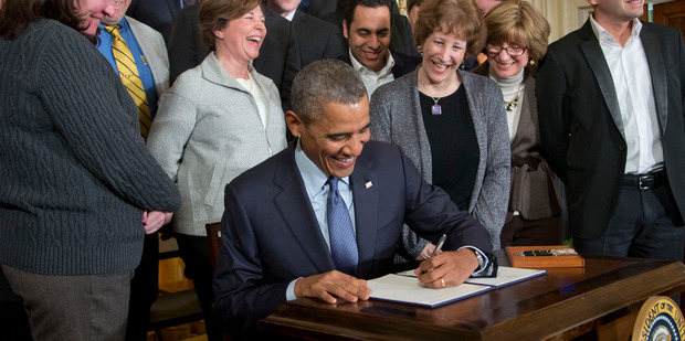Left-handed US President Barack Obama, center, signs a Presidential Memorandum. Photo / AP