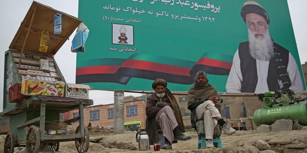 Abdul Rasoul Sayyaf, featured on the billboard, is one of a number of warlords involved in the election. Photo / AP