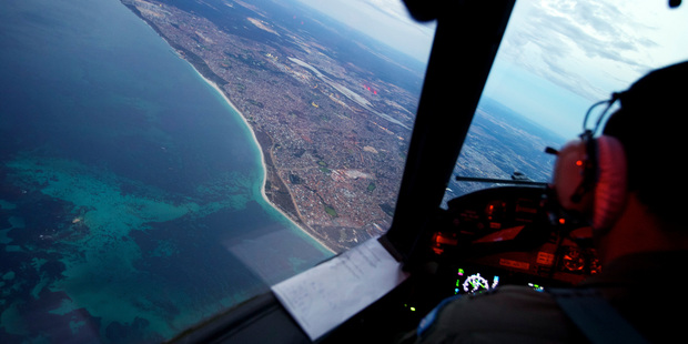 Crew on board an RAAF AP-3C Orion which having just completed an 11-hour search mission for MH370, control their aircraft on landing at RAAF Base Pearce in Perth, Australia. Photo / AP