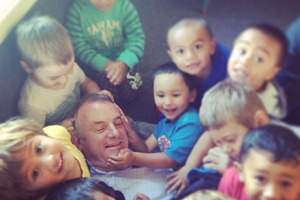 Trevor Mallard gets a 'facial' from kohanga reo children.