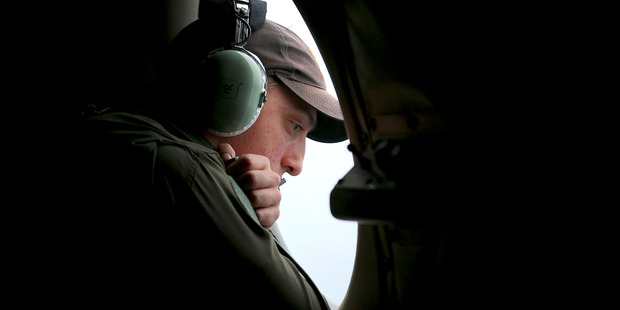 A crew member on board a Royal Australian Air Force AP-3C Orion, searches for the missing Malaysia Airlines Flight 370 in the southern Indian Ocean. Photo / AP