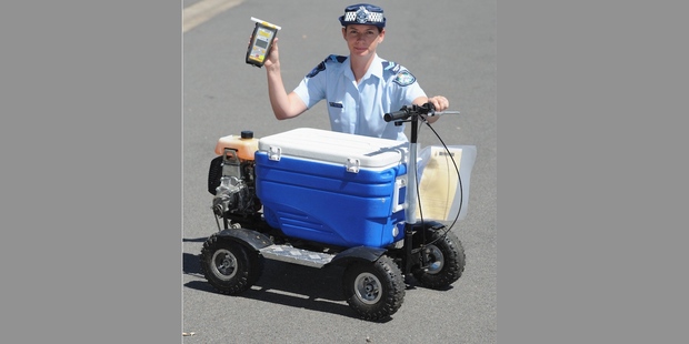 Snr Cnst Kelly Miles with a motorized esky that a man was alleged to have ridden in public whilst drunk. Photo: Alistair Brightman / Fraser Coast Chronicle