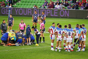 Knights players huddle as Alex McKinnon is prepared to be carried off on a stretcher. Photo / AP